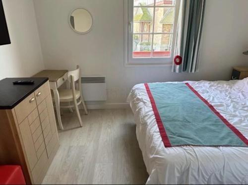 a bedroom with a bed and a desk and a window at Residence de la Plage Pierre et Vacances in Le Crotoy