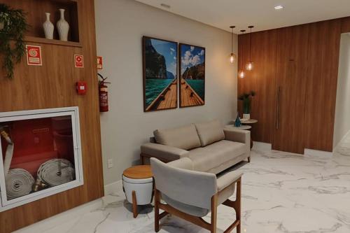 een woonkamer met een bank en een stoel bij Lindo apartamento em Guarapari - Novinho - Vista Maravilhosa in Guarapari