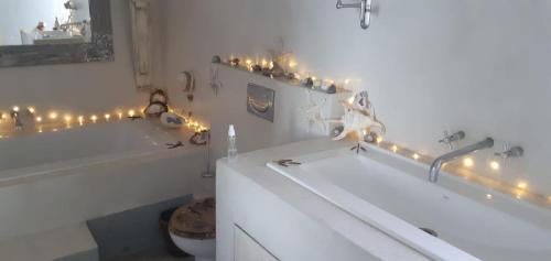 een badkamer met 2 baden en kerstverlichting bij Beachmusic in Kaapstad