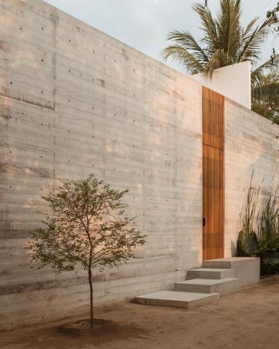 a concrete wall with stairs and a tree in front of it at Lunaya in Puerto Escondido