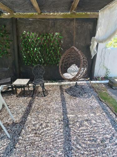 a patio with a swing and a bench and a chair at Visión ESCAPE Piriápolis in Piriápolis