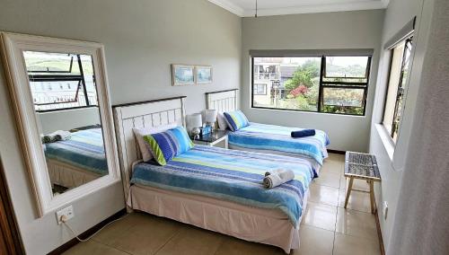 two beds in a room with two windows at Ankervas in Morganʼs Bay