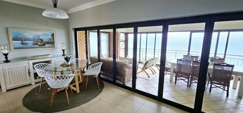 a dining room and living room with a table and chairs at Ankervas in Morganʼs Bay