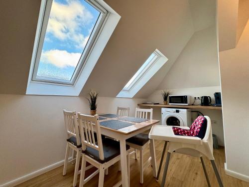 a dining room with a table and a window at Modernes City Apartment nahe Hbf in Emden