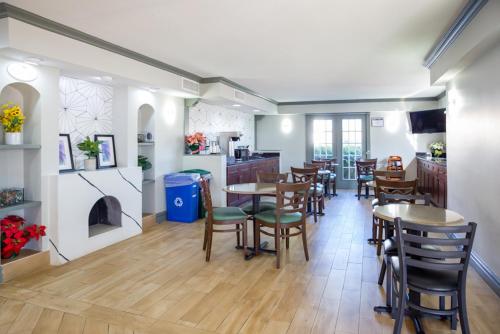 a dining room with tables and chairs and a kitchen at Baymont by Wyndham Austin University Area in Austin