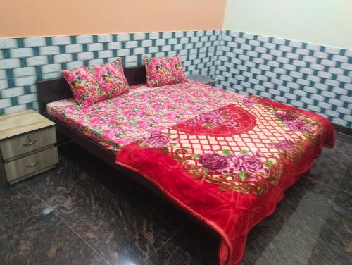 uma cama com um cobertor vermelho e almofadas em Gaurav bhawan em Vrindavan