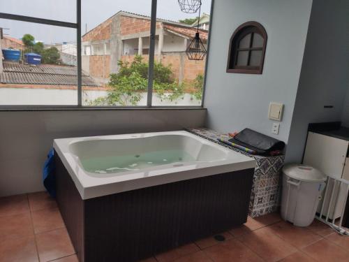 a large bath tub in a room with a window at Casa de praia em Cabo Frio até 12 hospedes in Cabo Frio