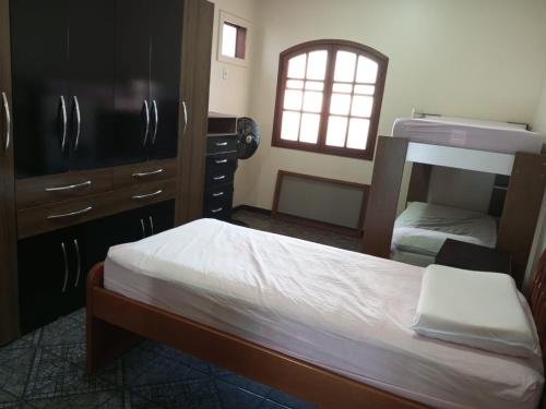 a bedroom with two bunk beds and a window at Casa de praia em Cabo Frio até 12 hospedes in Cabo Frio