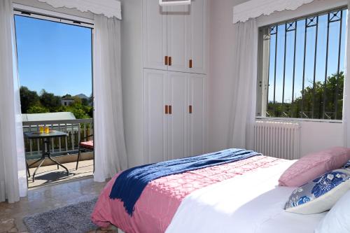 a bedroom with a bed and a balcony at To Spitaki Dalamanara in Dhalamanára