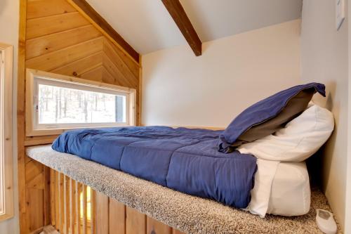a bed sitting on a ledge in a room with a window at Iron River Condo with Gas Grill Near Skiing and Hiking in Iron River
