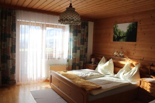 1 dormitorio con cama y ventana grande en Haus Hirschbichler, en Saalfelden am Steinernen Meer