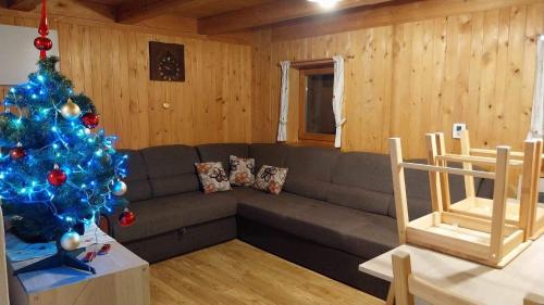a living room with a christmas tree and a couch at Počitniška hiša Jeklar in Bohinj