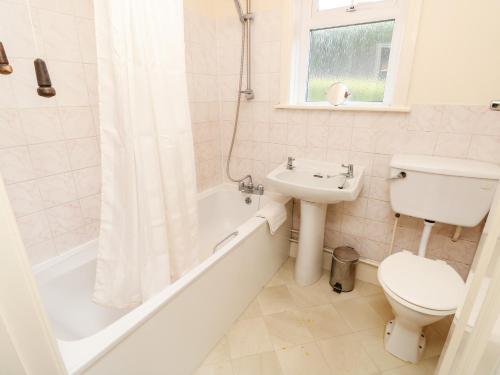 a bathroom with a toilet and a tub and a sink at Goodrest in Verwood
