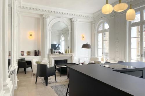 een woonkamer met een tafel en stoelen en een open haard bij l'Athéna - Standing - Hypercentre - 4pers in Rouen