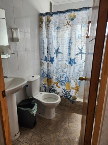 a bathroom with a toilet and a shower curtain at El Pescador in Iquique