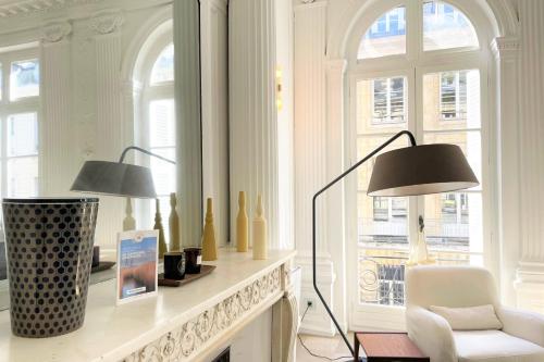 een woonkamer met 2 lampen en een stoel en een open haard bij l'Athéna - Standing - Hypercentre - 4pers in Rouen