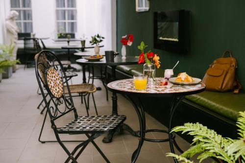 uma mesa e cadeiras com um prato de comida e sumo de laranja em Sonder Chelsea Green em Londres