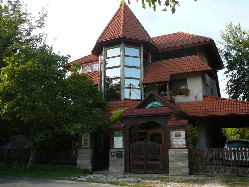 a large house with a tower on top of it at Porkoláb Apartmanház in Gyenesdiás