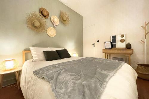 a bedroom with a large white bed with hats on the wall at l'Exotique - Vue Pl Vieux Marché - Standing in Rouen