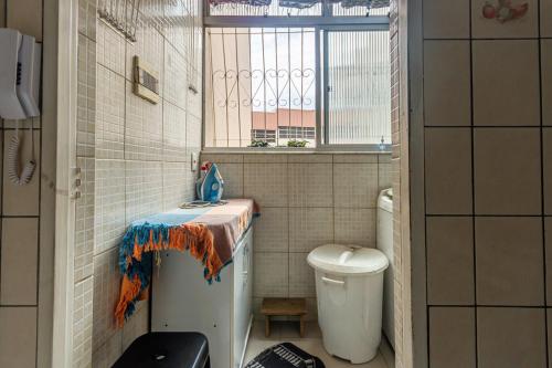 a small bathroom with a toilet and a window at Apto c otima localizacao em Gloria, Belo Horizonte in Belo Horizonte