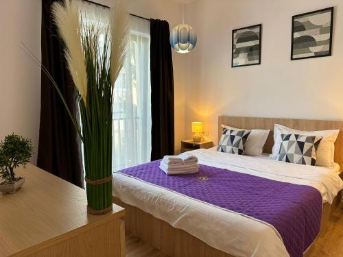 a bedroom with a large bed with a purple blanket at Lipatti 15 Premium Apartments by GLAM APARTMENTS in Timişoara