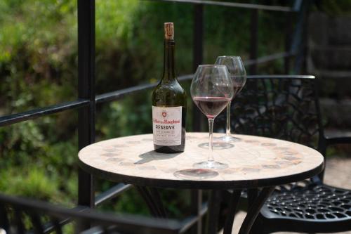 a bottle of wine sitting on a table with two glasses at Historic manoir in Vire Normandy elegance in a semi-rural setting ideal for groups and families in Vire