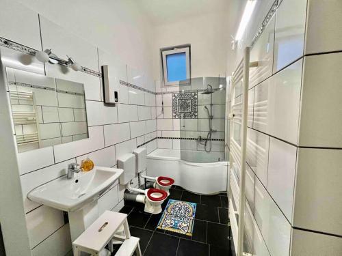 ein weißes Badezimmer mit einem Waschbecken, einer Badewanne und einem WC in der Unterkunft Villa Sartorius in Bovenden