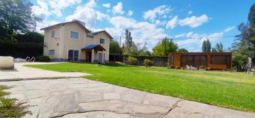 una casa con un patio de césped con una casa en CHACRAS Lodge en Mendoza