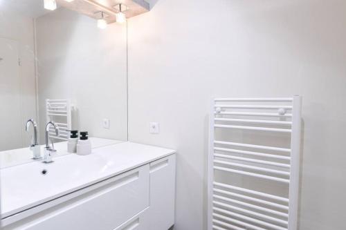 a white bathroom with a sink and a mirror at ORNANO Épuré Moderne Transports in Saint-Denis