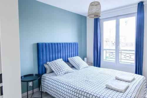 a bedroom with a bed with blue walls and a window at ORNANO Épuré Moderne Transports in Saint-Denis