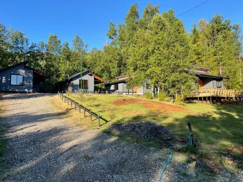 a group of cottages in the woods with a driveway at Cabañas Altos del Bosque in Licán Ray