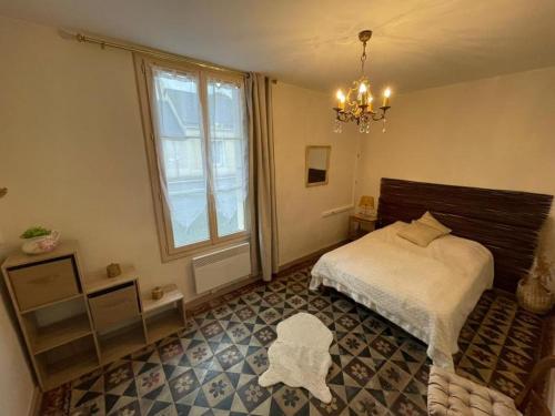 ein Schlafzimmer mit einem Bett und einem großen Fenster in der Unterkunft Appartement rez de jardin in La Chartre-sur-le-Loir