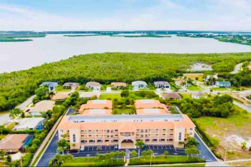 an aerial view of a building with a lake in the background at Amazing & Spacious Top Floor Condo with Bay View! in Marco Island