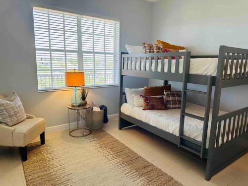 a bedroom with two bunk beds and a chair at Amazing & Spacious Top Floor Condo with Bay View! in Marco Island
