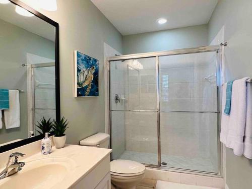 a bathroom with a shower and a toilet and a sink at Amazing & Spacious Top Floor Condo with Bay View! in Marco Island