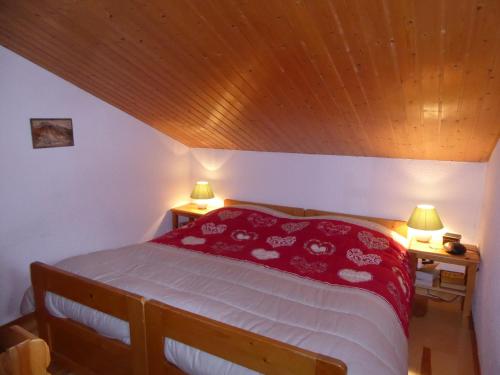 プラローニャン・ラ・ヴァノワーズにあるAppartement Pralognan-la-Vanoise, 3 pièces, 4 personnes - FR-1-464-94のベッドルーム1室(赤いベッド1台、ランプ2つ、テーブル2台付)