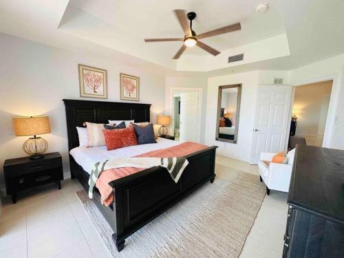a bedroom with a large bed and a ceiling fan at Amazing & Spacious Top Floor Condo with Bay View! in Marco Island