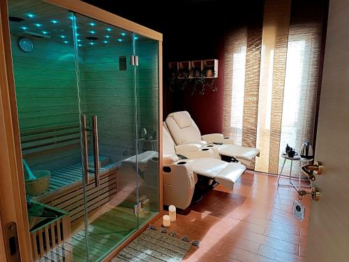 a bathroom with a toilet and a glass shower at Ti Scialíi Suites Rooms and Relax in Pachino