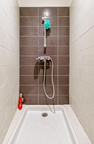 La salle de bains est pourvue d'une baignoire avec un tuyau. dans l'établissement Coquette Maison de Village, à Maillane