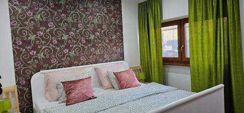 una camera da letto con un letto con tende verdi e una finestra di AG Euro Apartments a Gabčíkovo