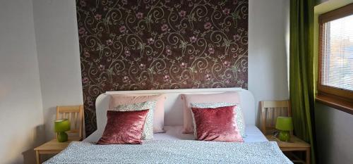 una camera da letto con un letto con cuscini rossi di AG Euro Apartments a Gabčíkovo