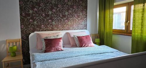 een slaapkamer met een bed met roze kussens en een raam bij AG Euro Apartments in Gabčíkovo