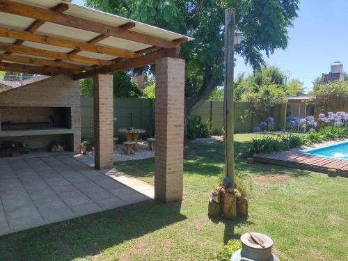 a patio under a wooden pergola next to a pool at Alma Mía in Lobos