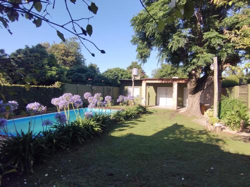 a garden with a swimming pool in a yard at Alma Mía in Lobos