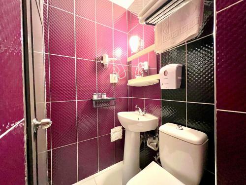 Baño de color rosa con aseo y lavamanos en Cord Hotel & Resort, en Edremit