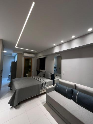 a bedroom with a bed and a couch at Muro alto - porto de galinhas -Makia beach in Ipojuca