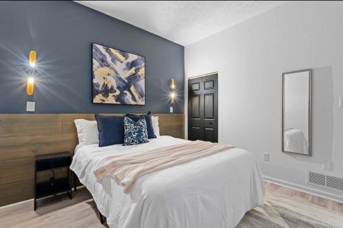 a bedroom with a large bed with blue walls at Northside Pittsburgh Luxurious Apartment in Pittsburgh