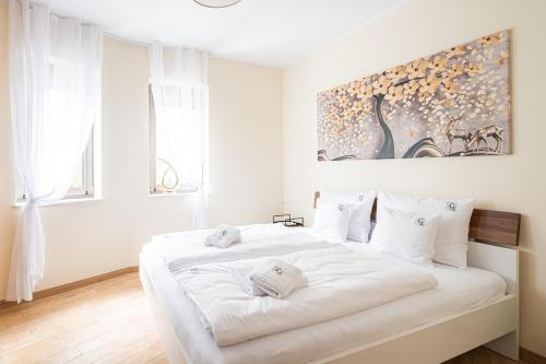 een witte slaapkamer met een groot wit bed met witte kussens bij Szklarska C13 in Szklarska Poręba