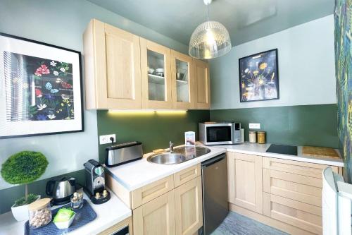 une cuisine avec un évier et un micro-ondes dans l'établissement Les 3 Clochers - Cosy et Confort - Hypercentre, à Rouen