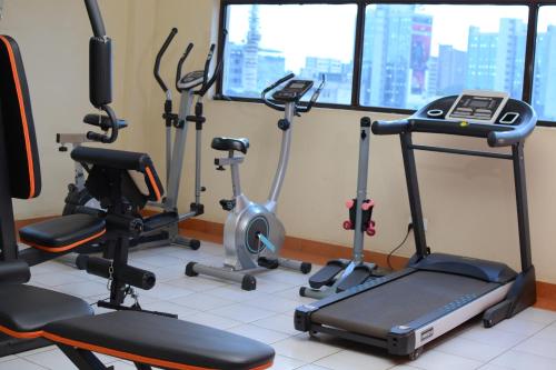 a gym with several exercise bikes and a treadmill at QUINTEN HOTEL KISUMU in Kisumu